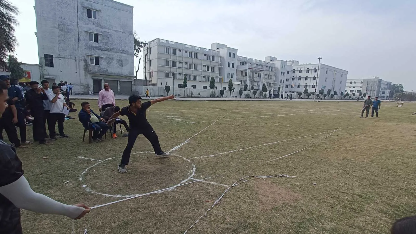 Student competing in a shot put event on the campus sports field during Sports Day