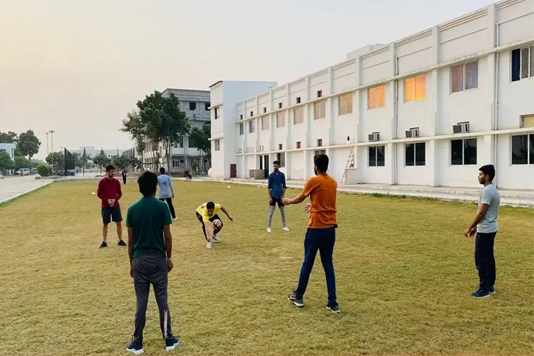 Students playing volleyball on the campus lawn at sunset